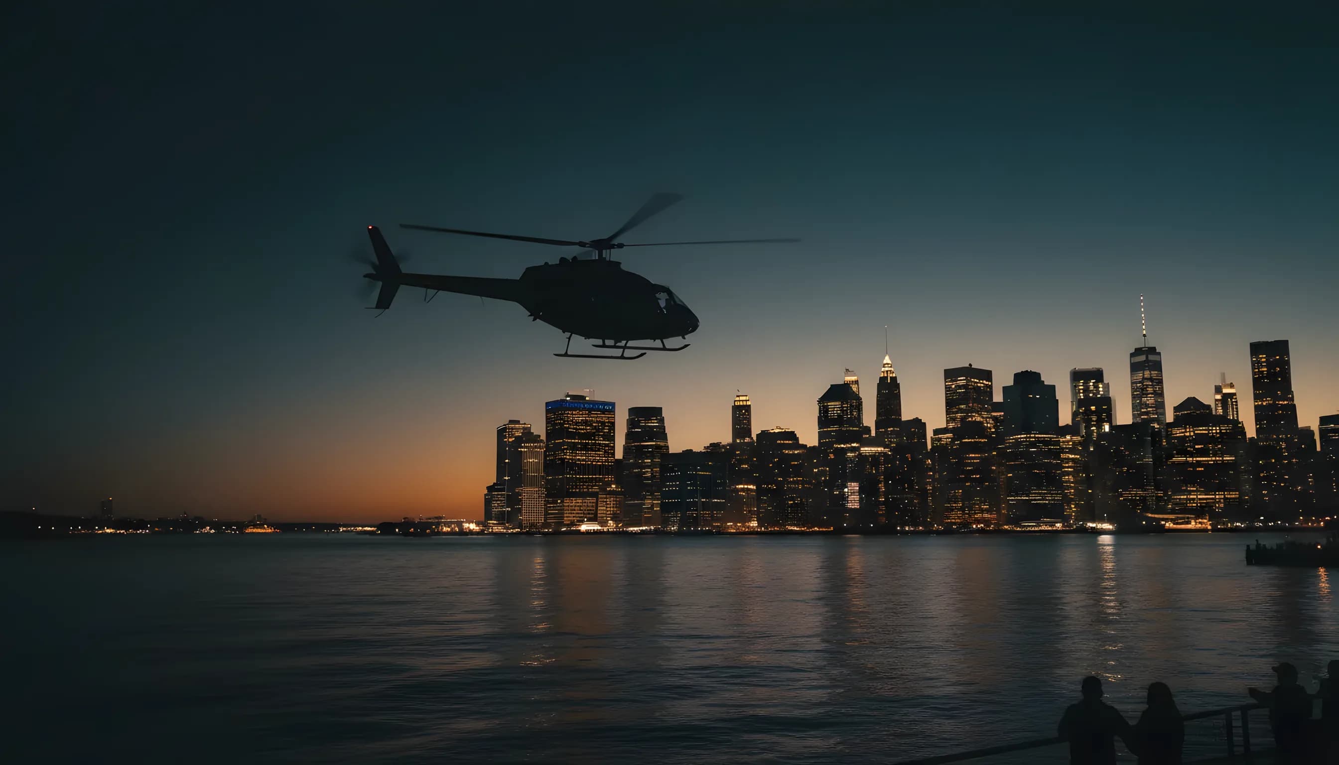 A helicopter flies over a river at dusk, with the illuminated skyline of Manhattan in the background.