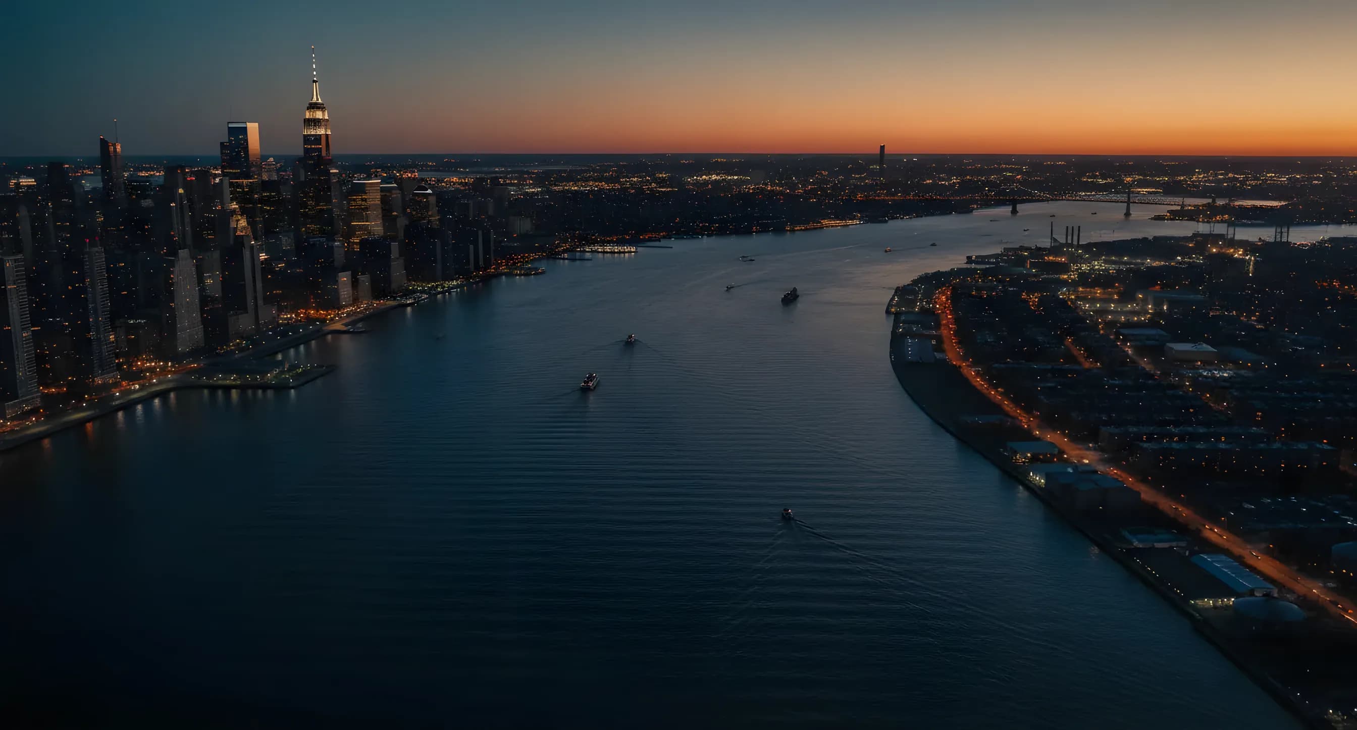 Aerial view of the Manhattan skyline and Hudson River at dusk from a helicopter.