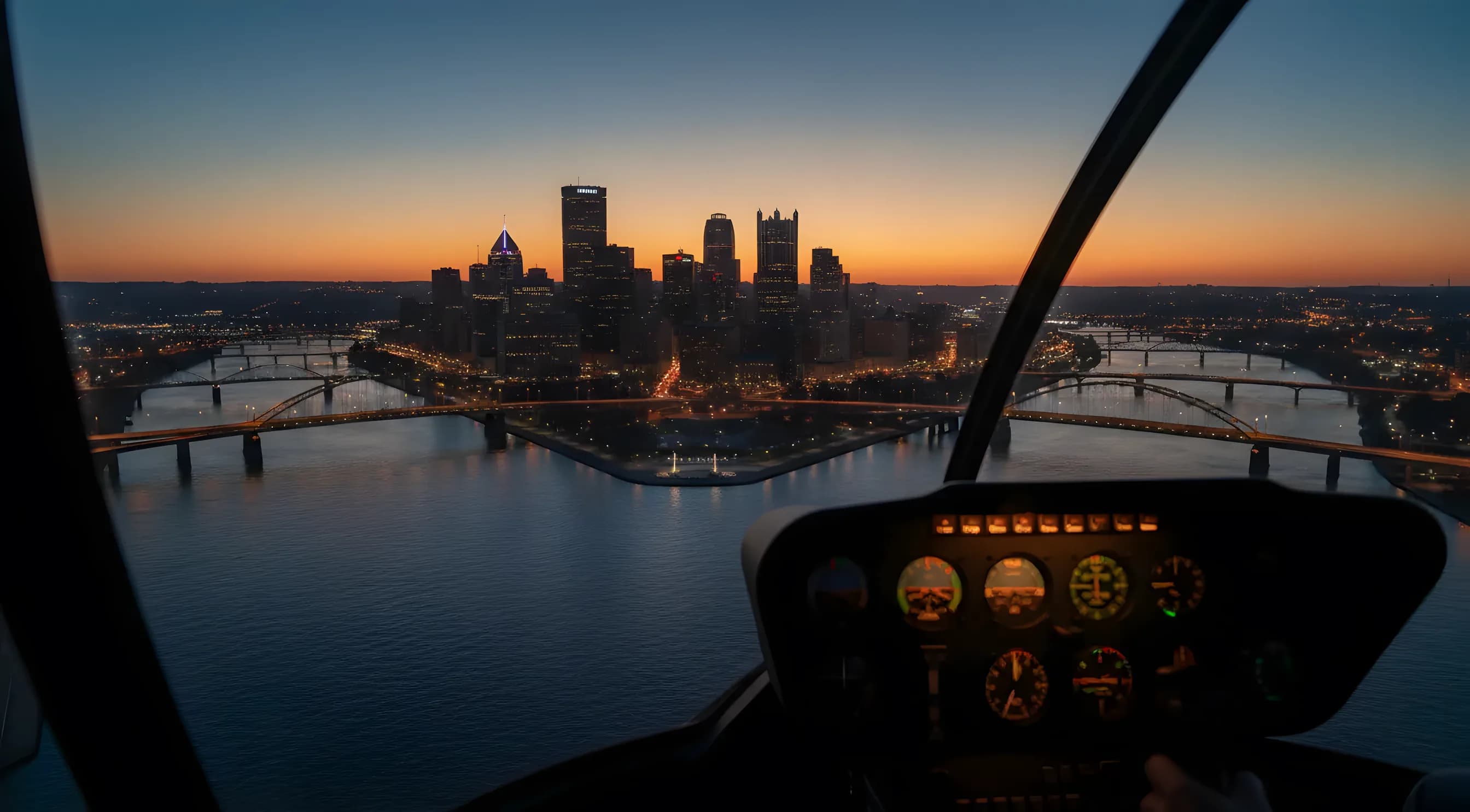 Aerial view of the Pittsburgh skyline and its three rivers at dusk.