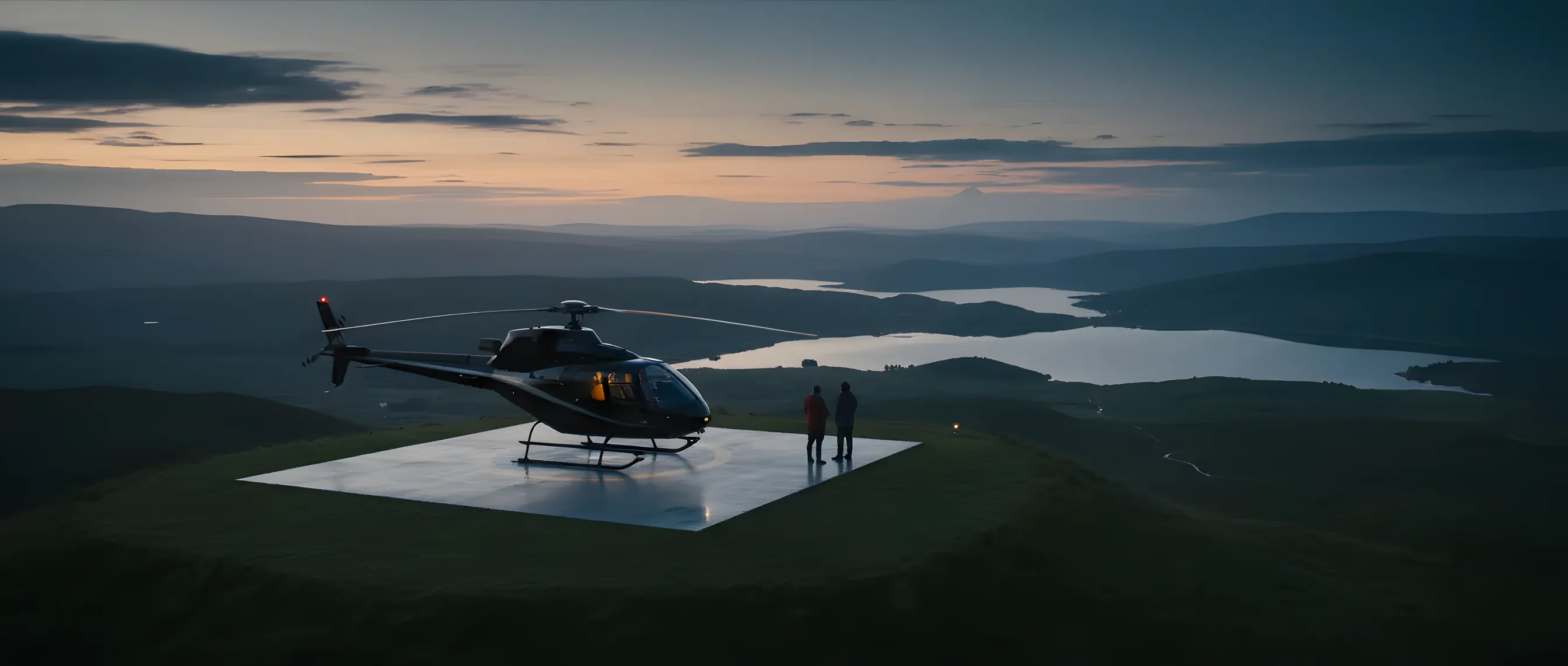 A helicopter parked in the vast, misty landscape of the Scottish Highlands.