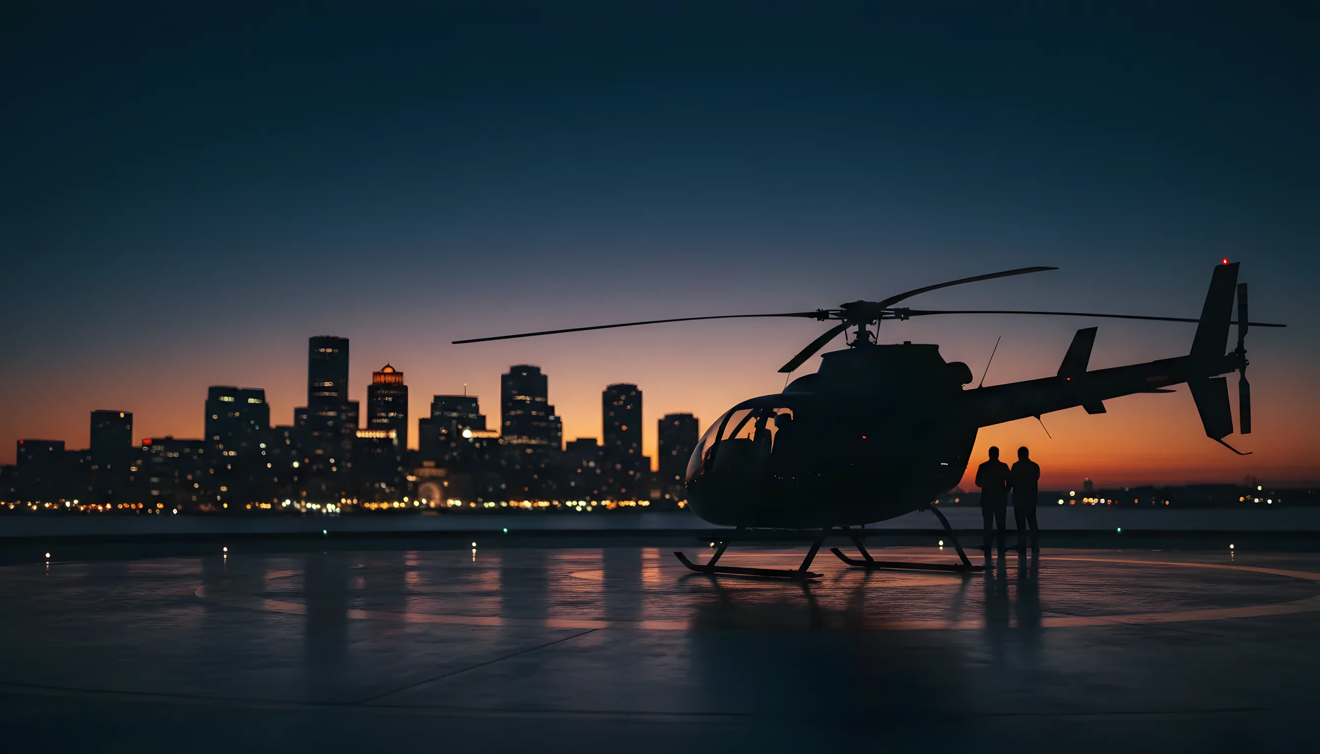 A black helicopter sits on a helipad at dusk with the blurred lights of the Boston skyline in the background.