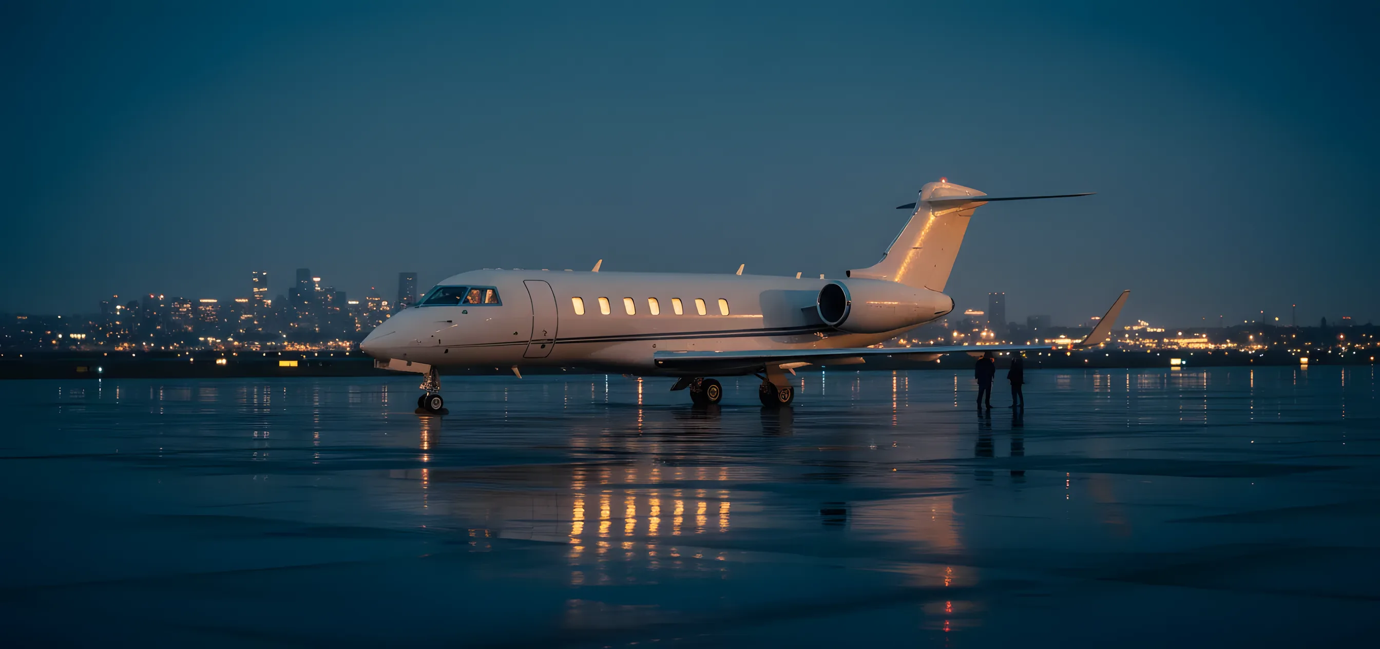 A private jet on an airport tarmac at dusk, with a city skyline in the distance.