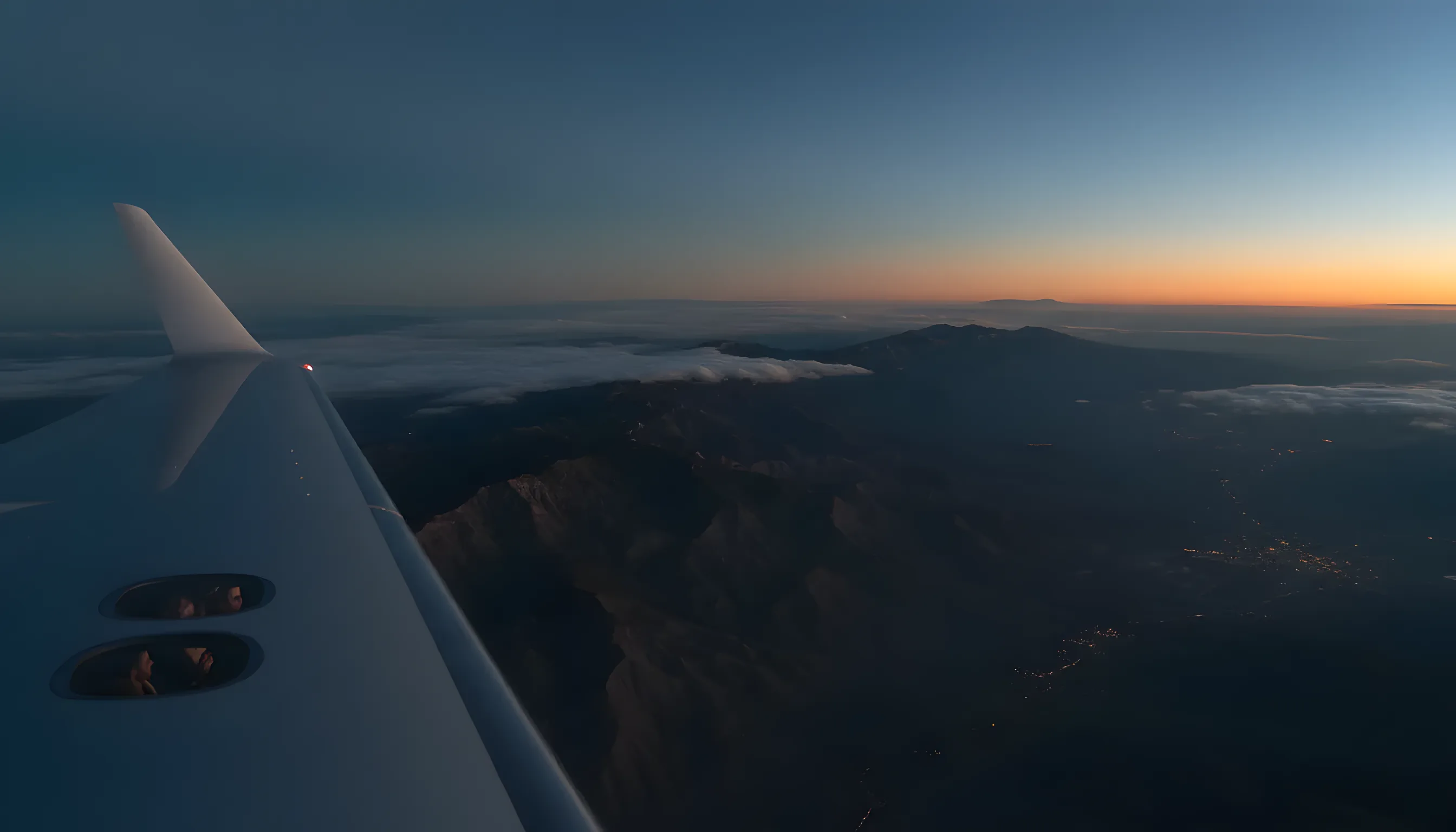 Aerial view of the Franklin Mountains at sunrise from the wing of a private jet.