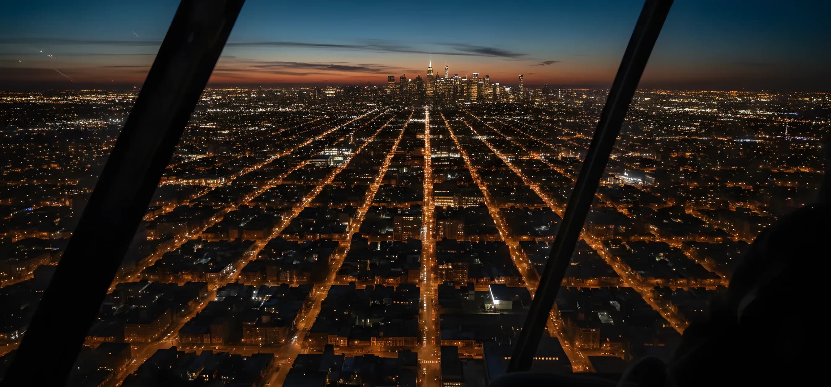 Aerial view of New York City at dusk, looking from Queens towards the Manhattan skyline.