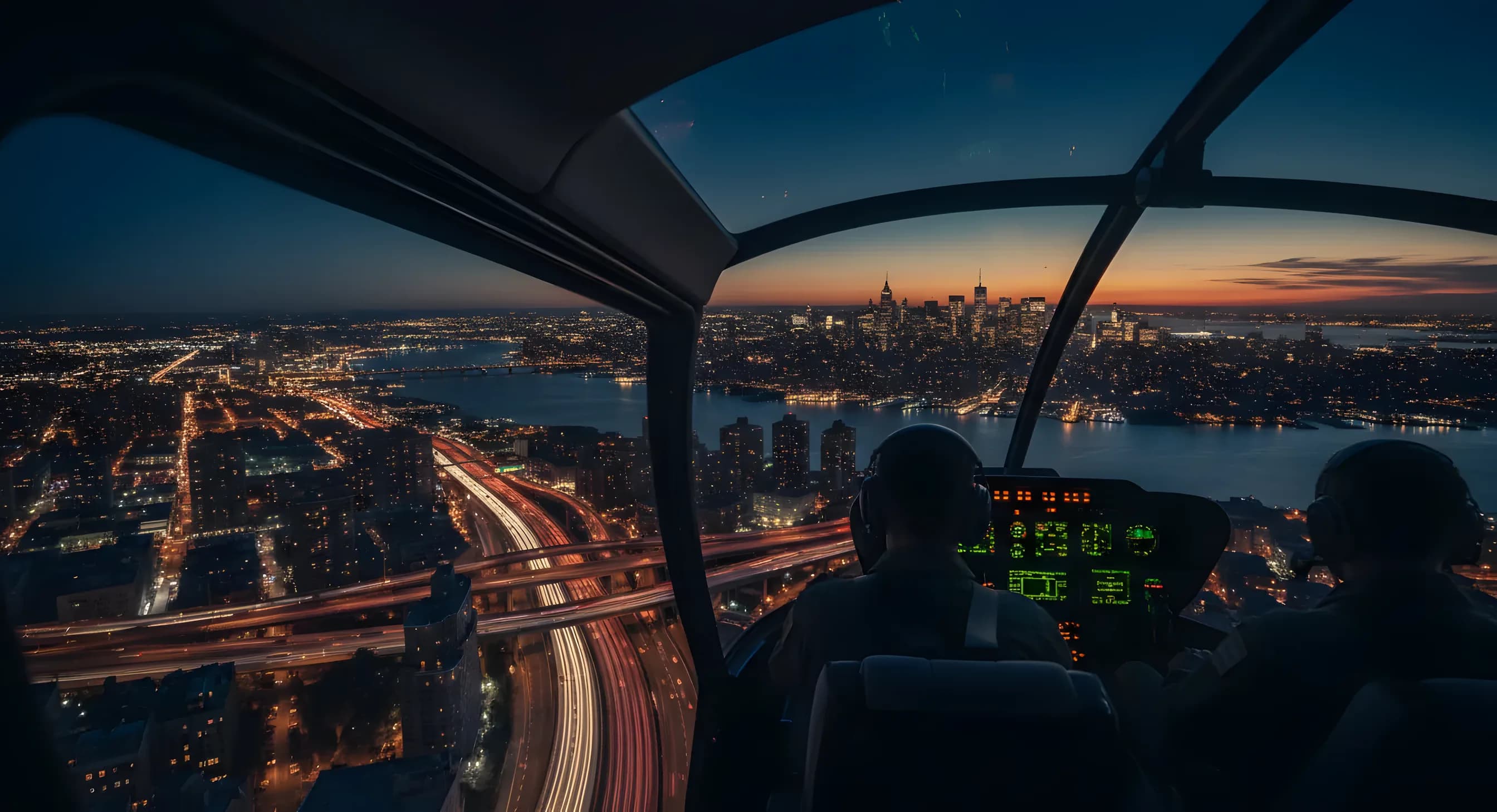 View of the Manhattan skyline at dusk from a helicopter cockpit, with city lights and traffic below.
