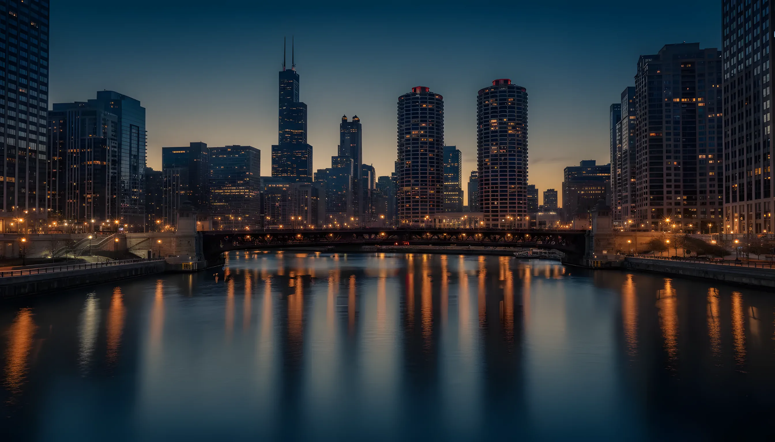 The Chicago River at dusk with Willis Tower, Marina City and lit bridges.