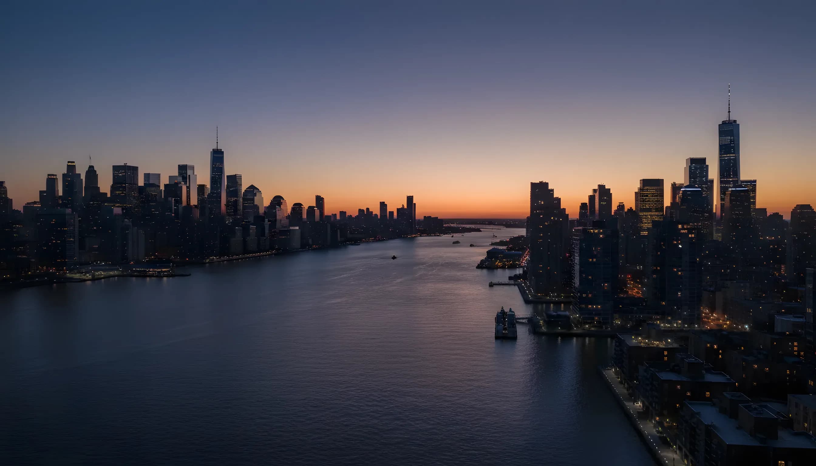 Aerial view south over the Hudson River at dusk between Manhattan and the New Jersey waterfront.
