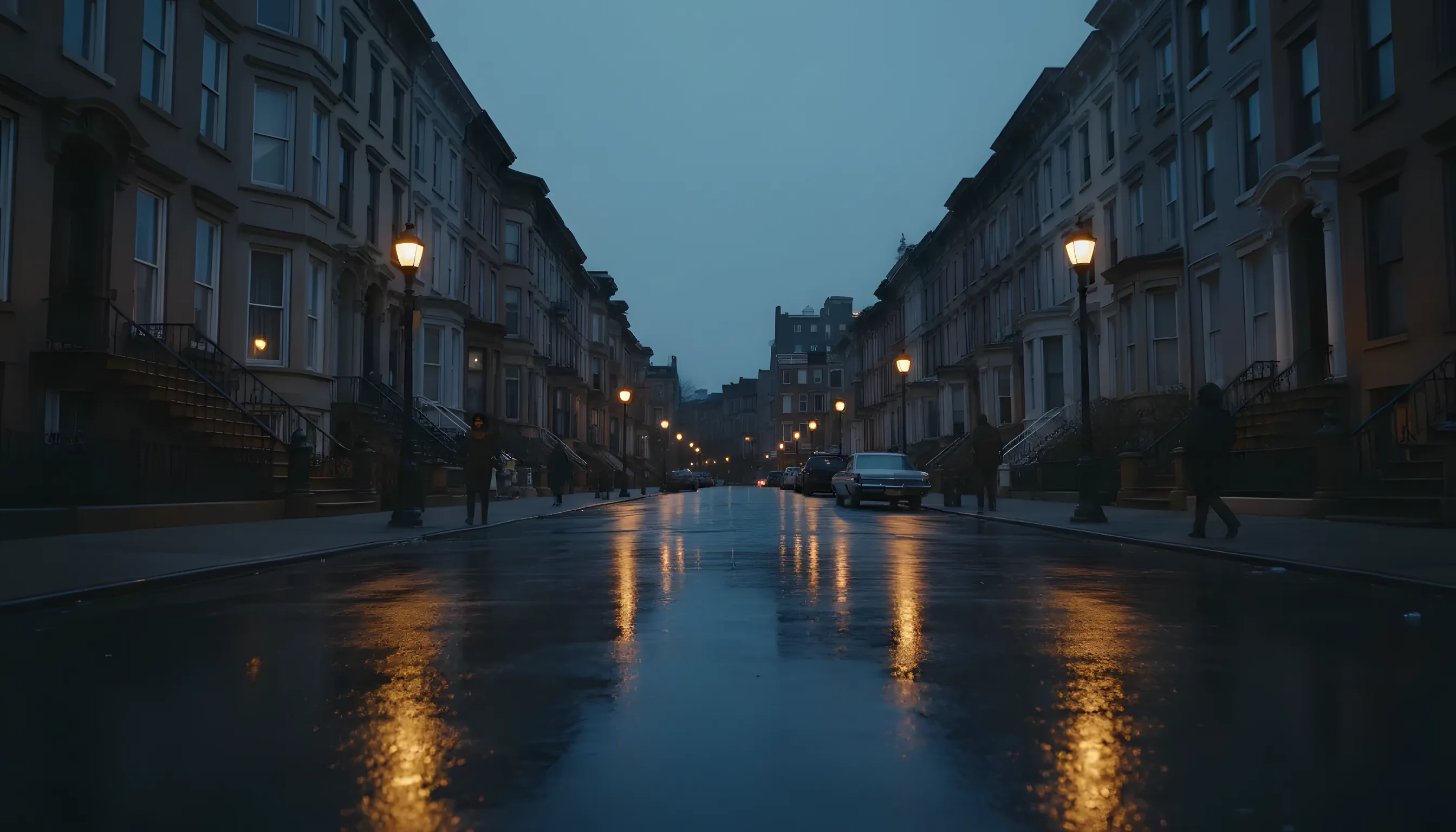 A tree-lined street with historic brownstone buildings in Brooklyn at dusk, with warm lights glowing from windows and street lamps.
