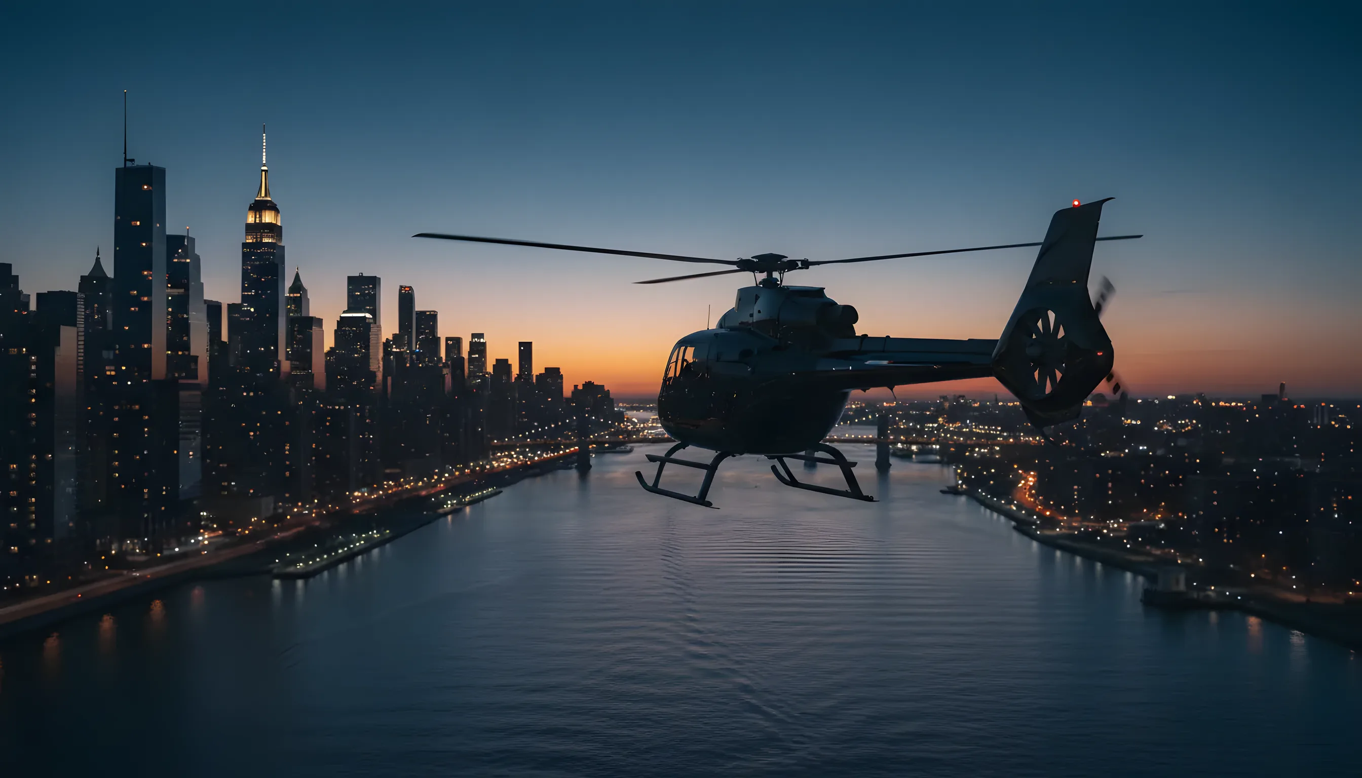 A helicopter flies over a sprawling city skyline at dusk, with lights beginning to illuminate the buildings.