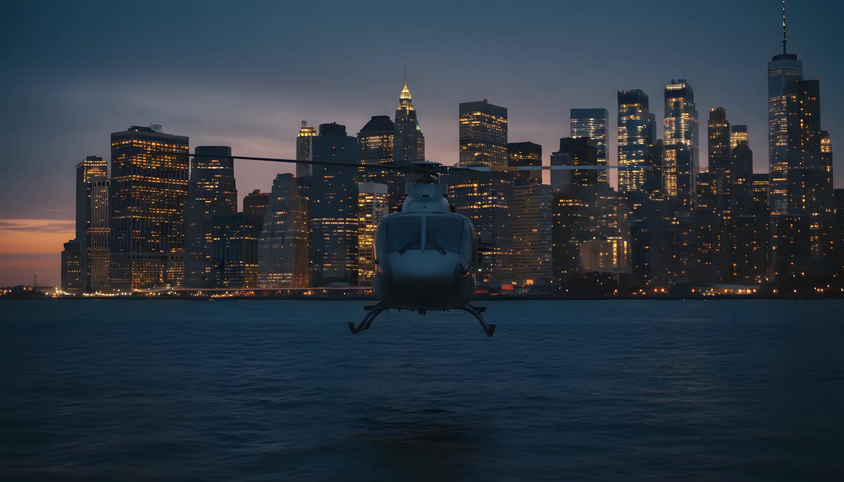 A helicopter flies over the water at dusk, with a glowing city skyline in the background.