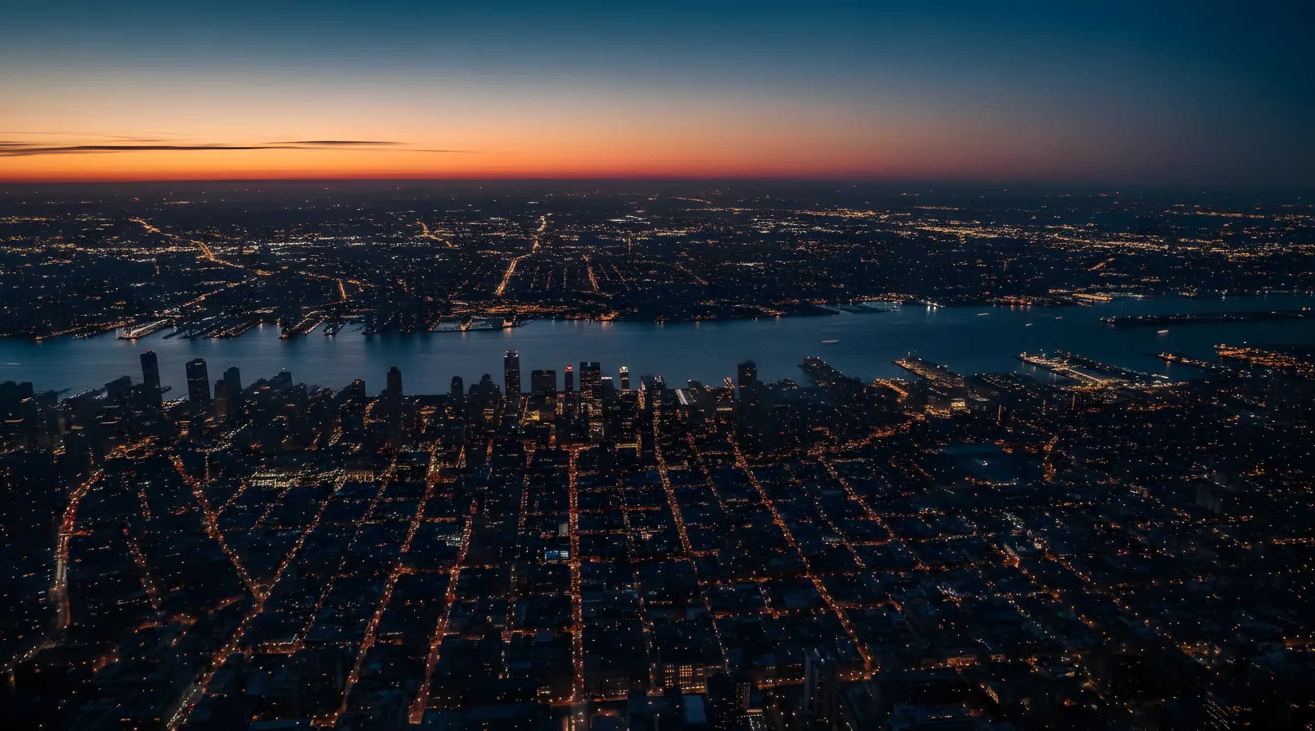 Aerial view of the Manhattan skyline and surrounding boroughs at twilight from a helicopter.