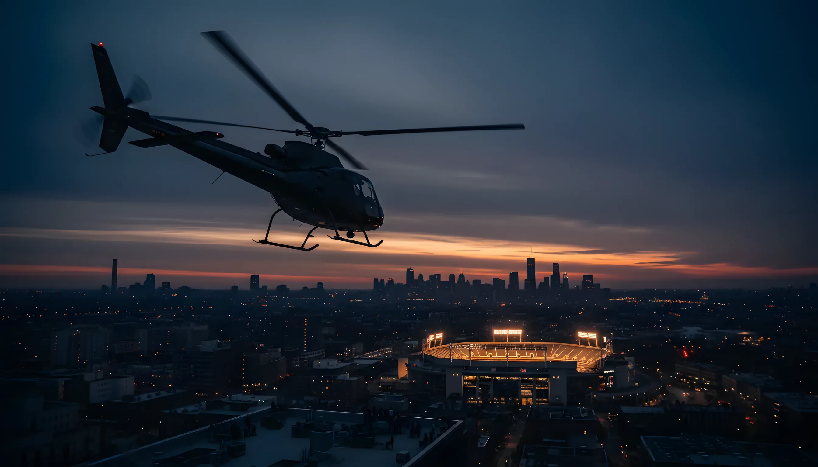 A helicopter flies over New York City at dusk toward a brightly lit tennis stadium.
