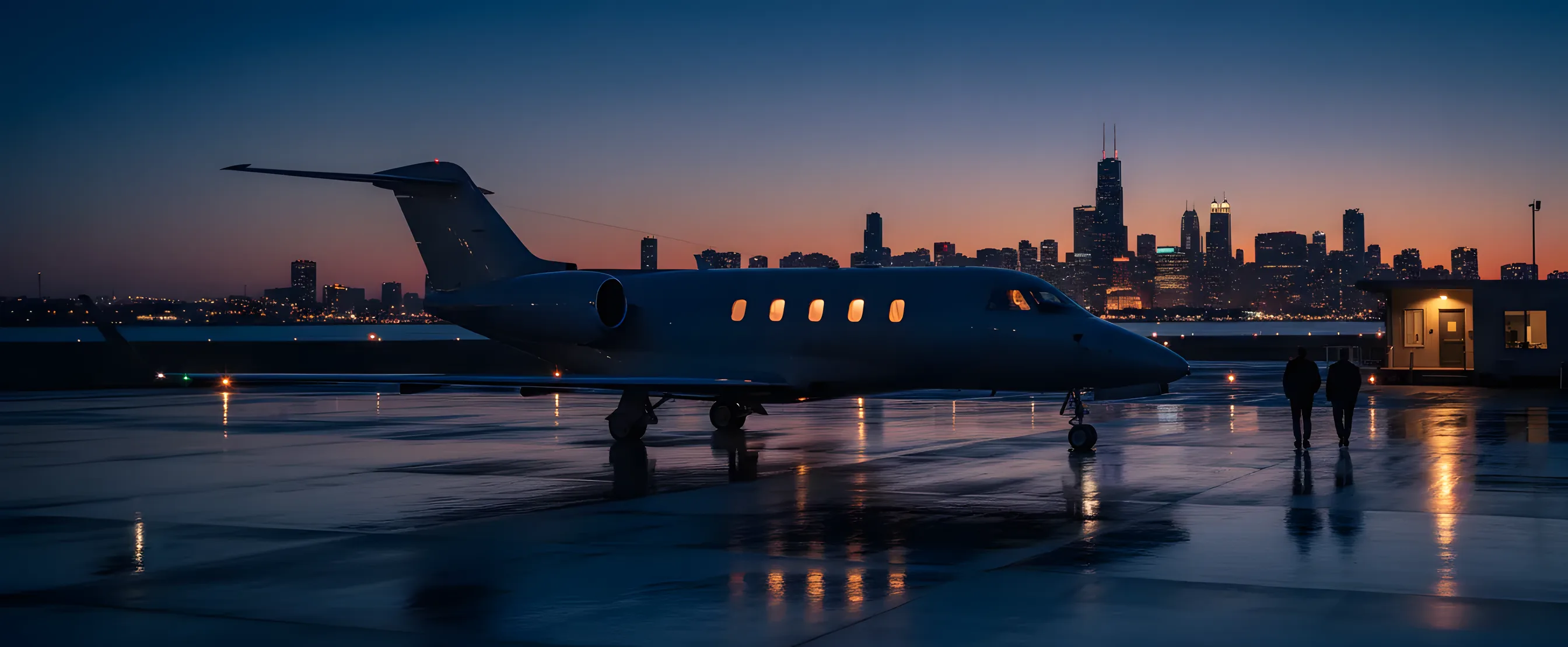 A private jet on an airport tarmac at dusk, with the glowing Chicago skyline in the distance.