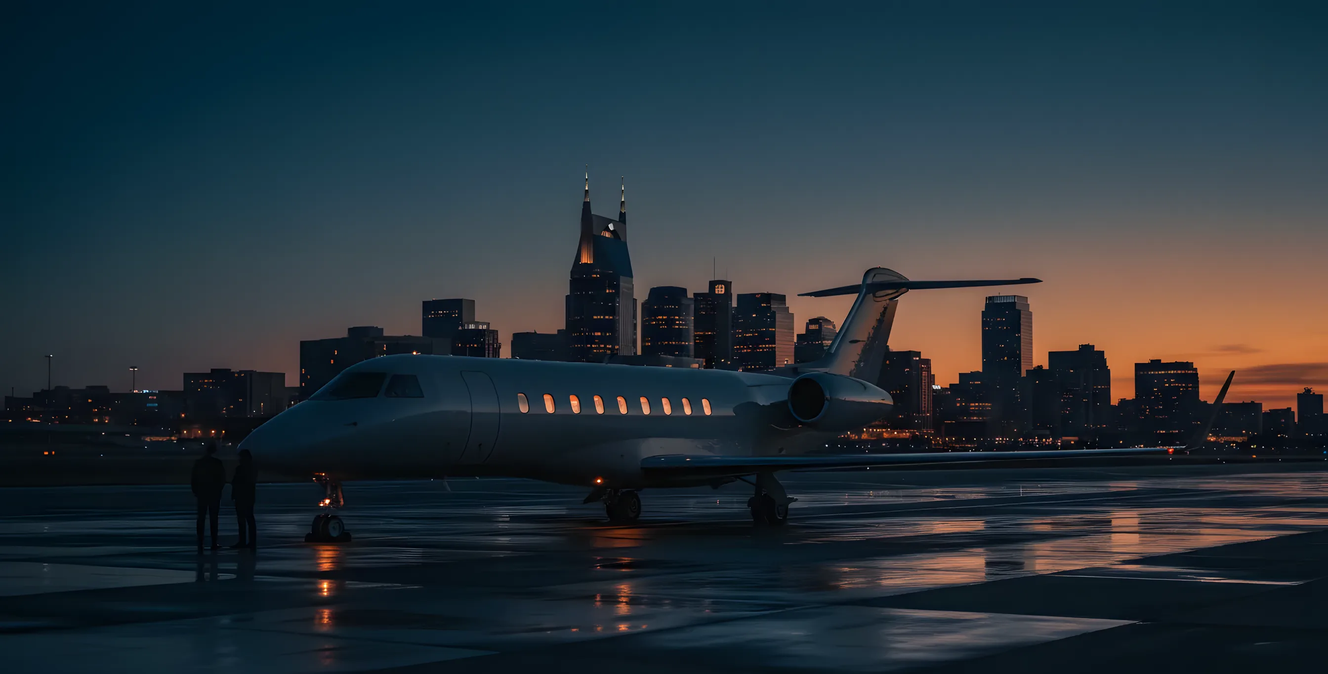 A private jet on the tarmac at dusk with the glowing Nashville skyline in the distance.