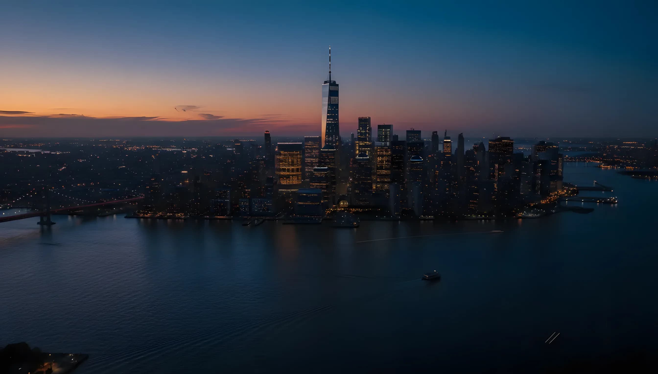 Aerial view of the Downtown Manhattan skyline and the Hudson River at dusk.
