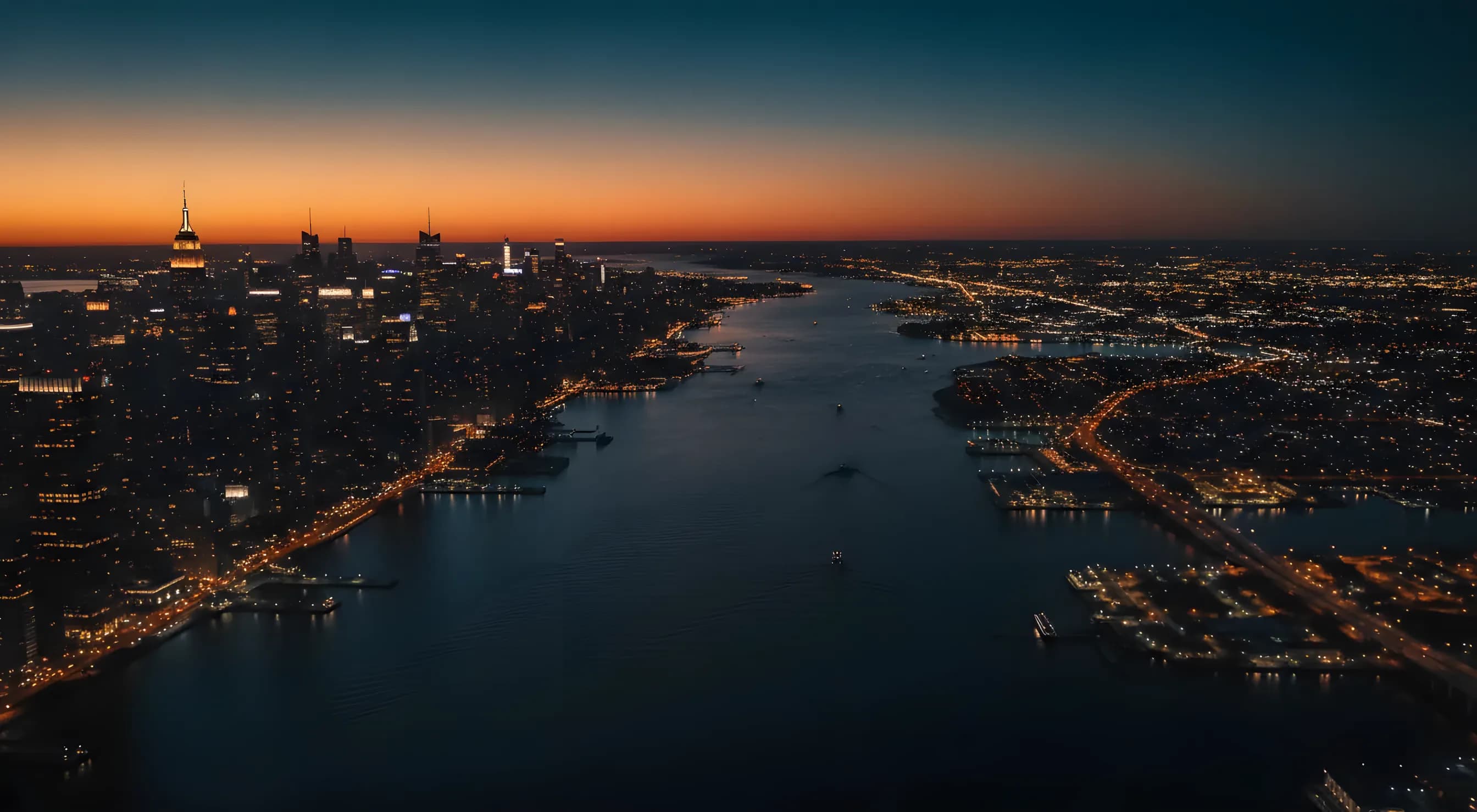 Aerial view of the Midtown Manhattan skyline and New Jersey at dusk from over the Hudson River.