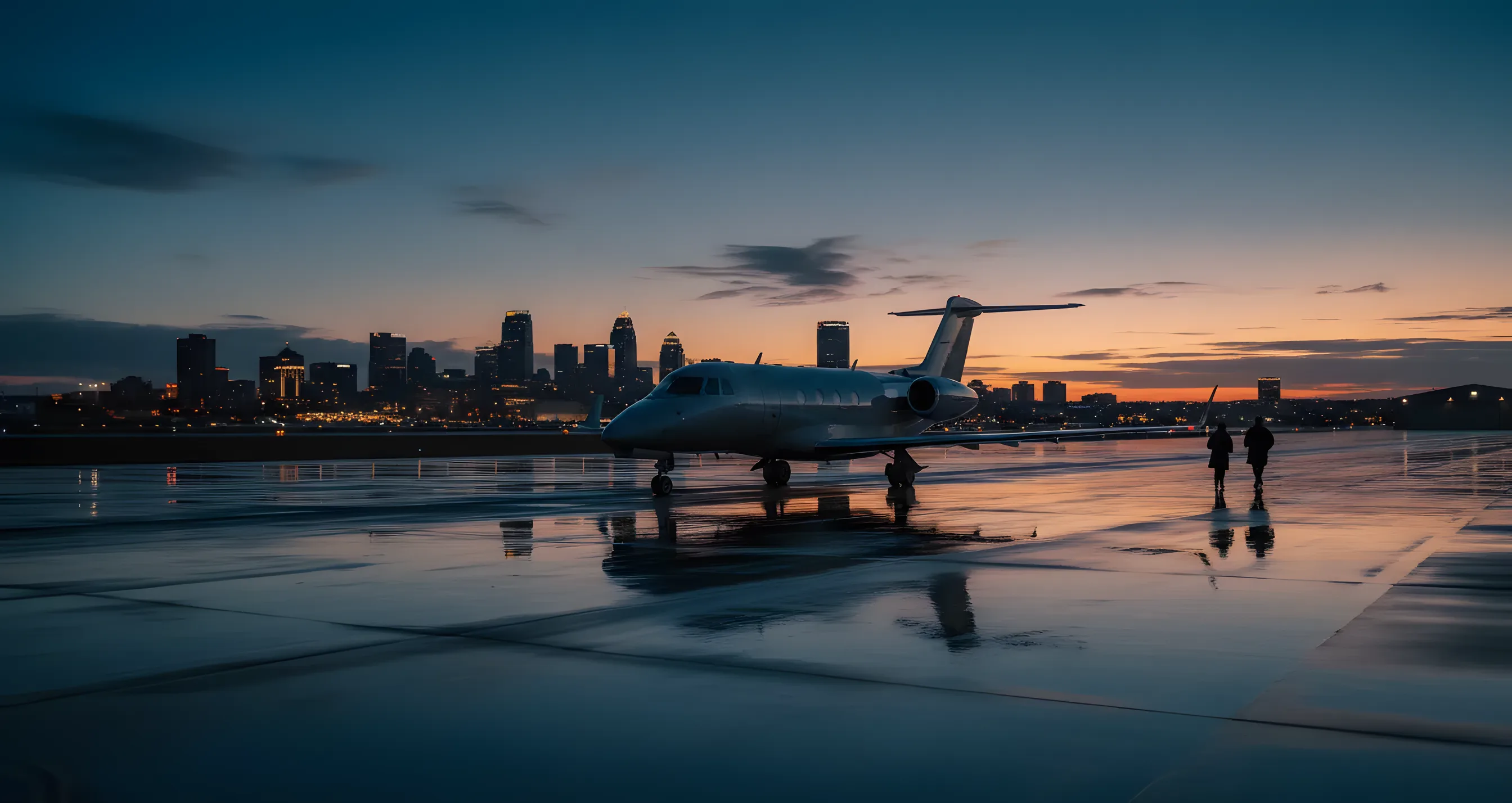 A private jet on an airfield at dusk with the Omaha city skyline in the background.