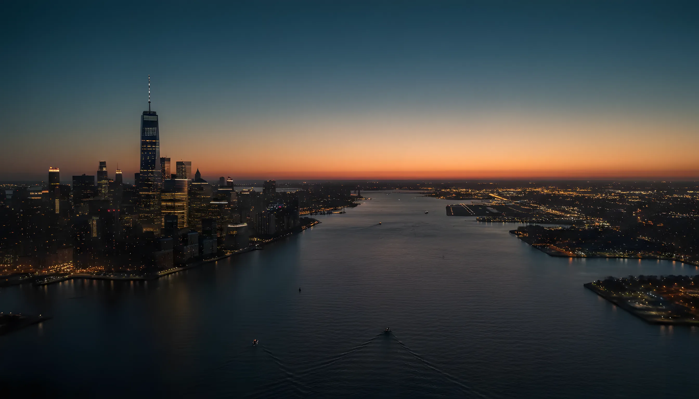 Aerial view of the Manhattan skyline and New Jersey at dusk from a helicopter over the Hudson River.