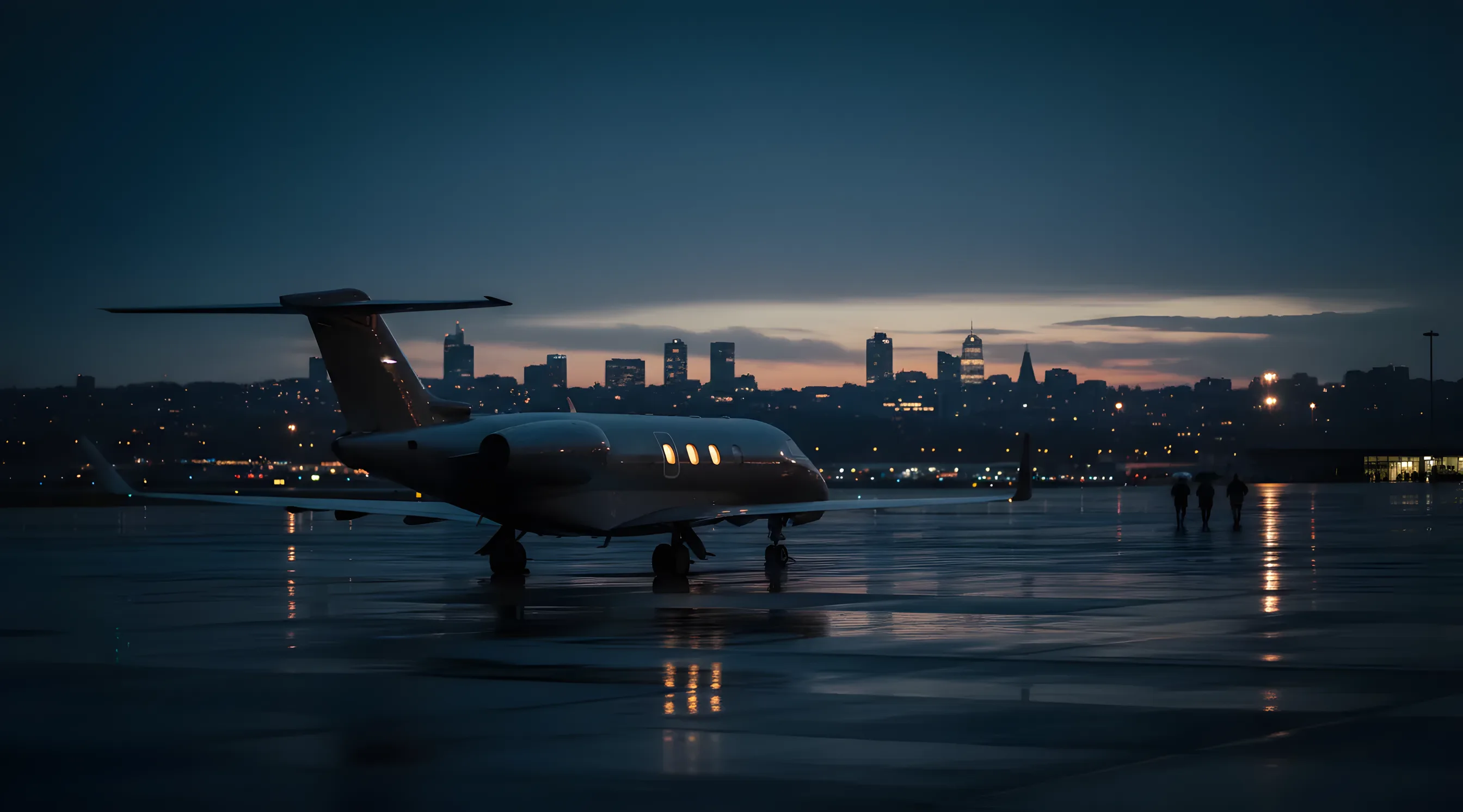 A private jet on an airport tarmac at twilight, with the lights of a city in the distance.