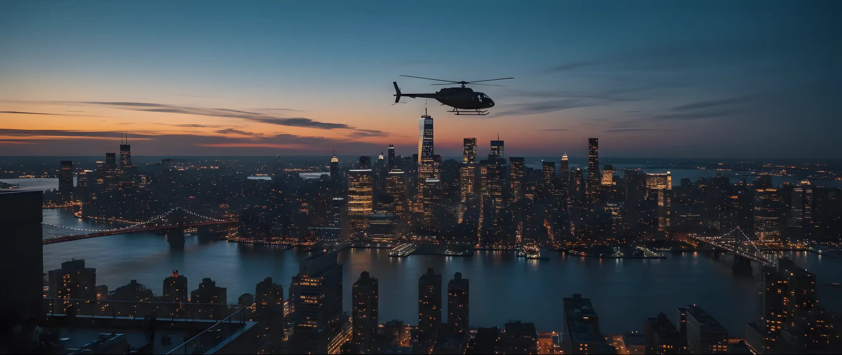 The Manhattan skyline glows with city lights at dusk, viewed from across the river as a helicopter approaches.