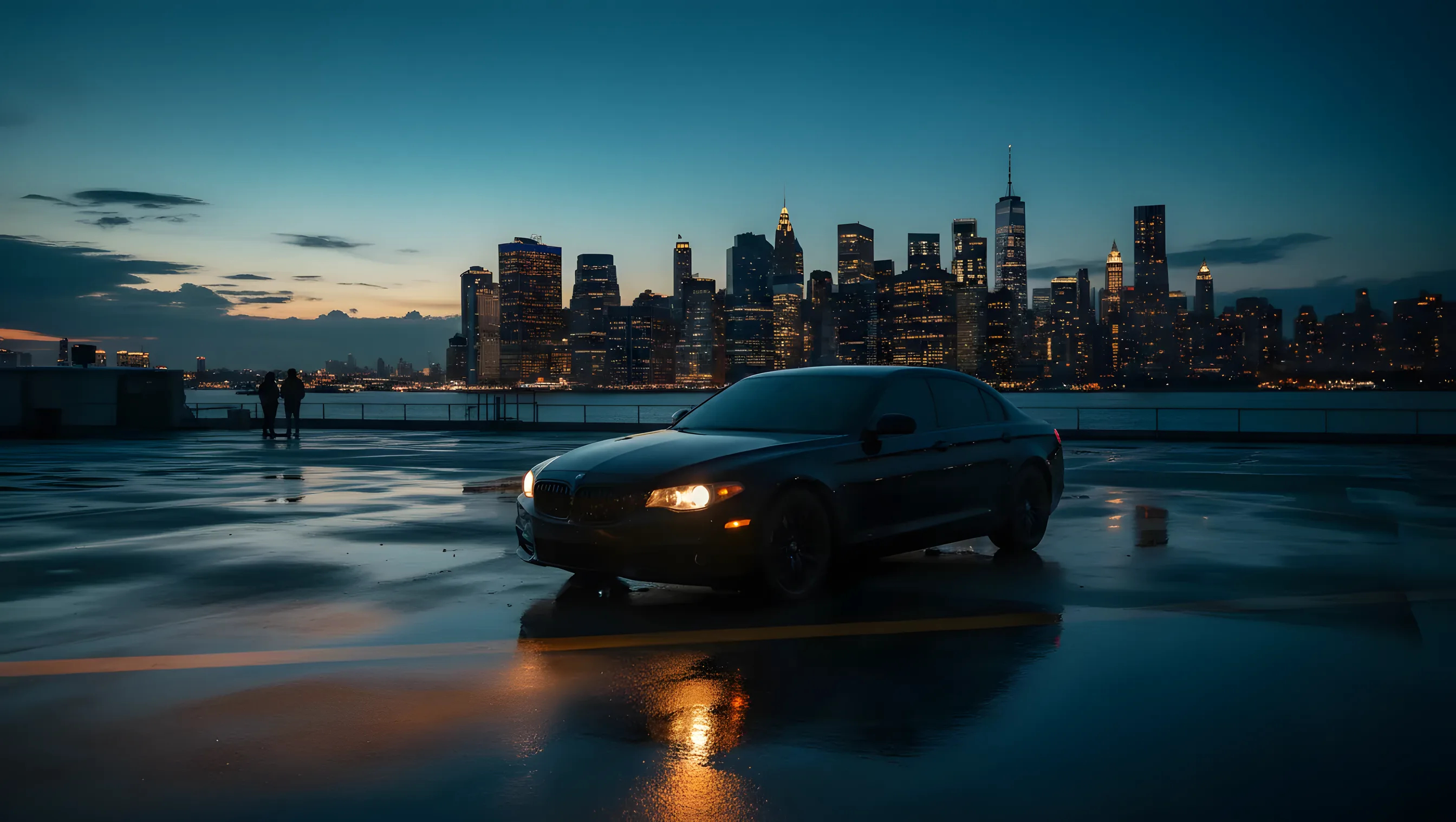 A black luxury car on a heliport tarmac with the New York City skyline at dusk.