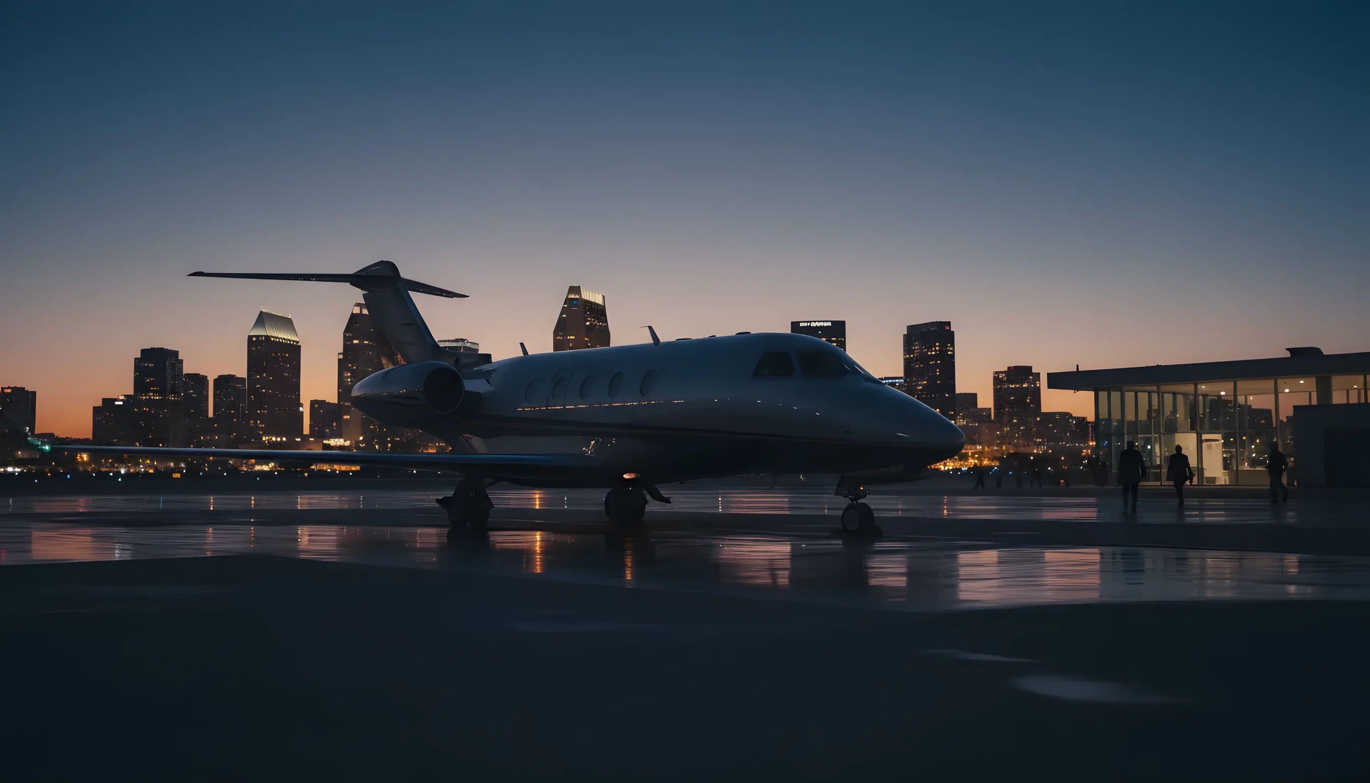 A private jet on an airfield at dusk with the San Diego skyline glowing in the background.