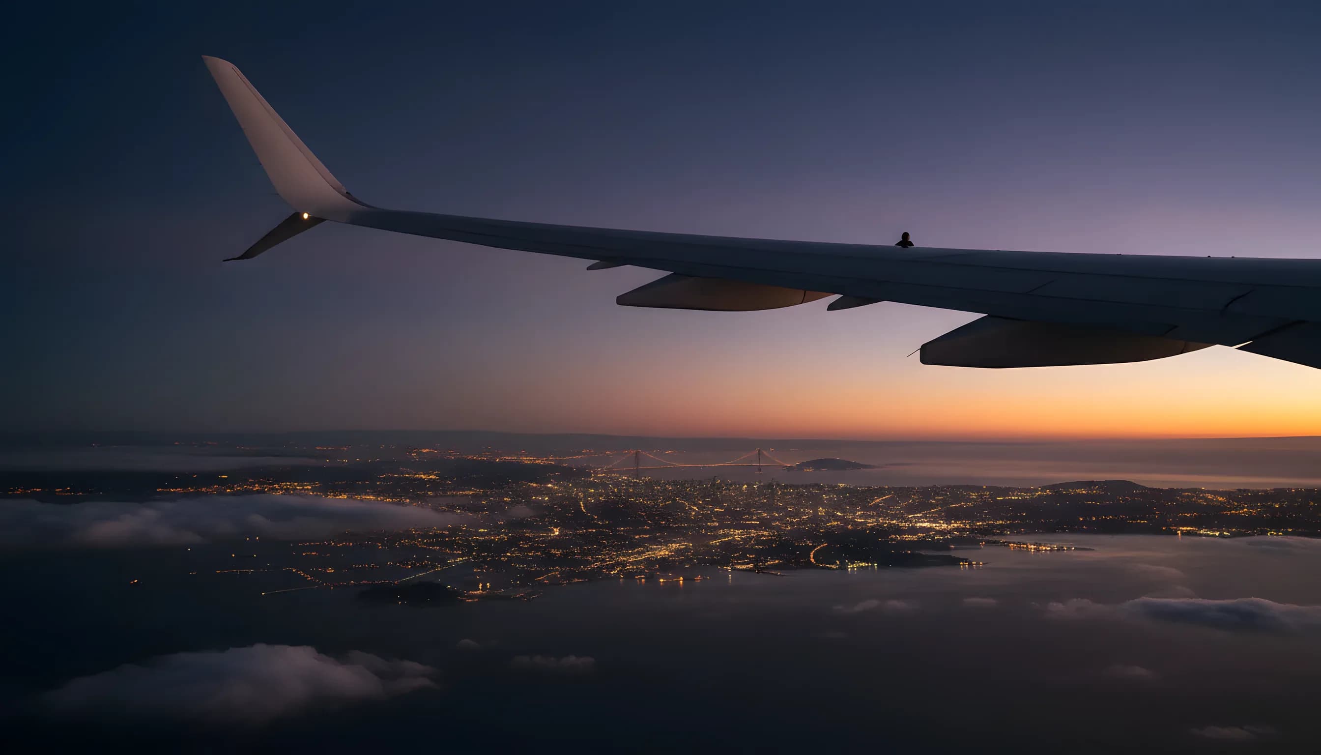 Aerial view of the San Francisco bay area at dusk from an airplane window.