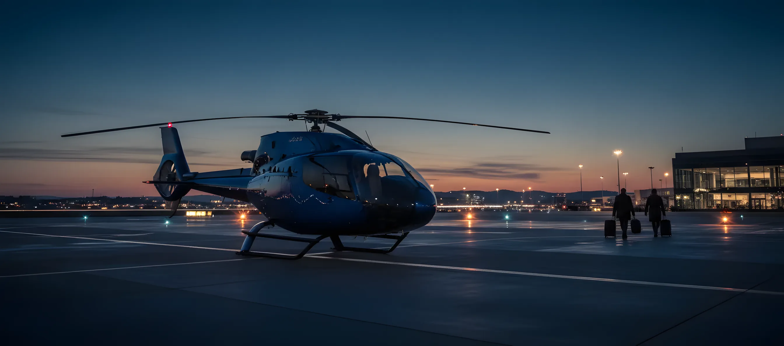 A black BLADE helicopter parked on an airport tarmac under a clear blue sky.