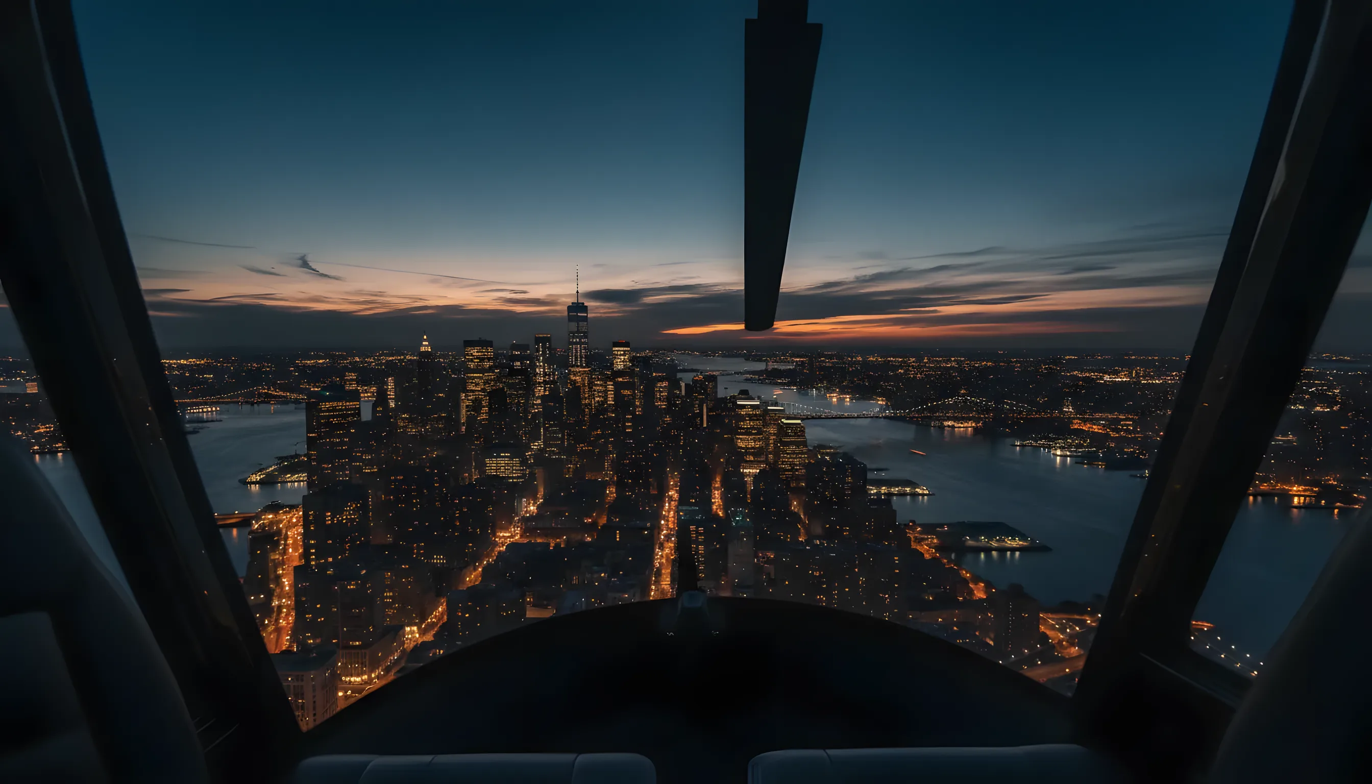 Aerial view of the Lower Manhattan skyline at dusk from inside a helicopter.