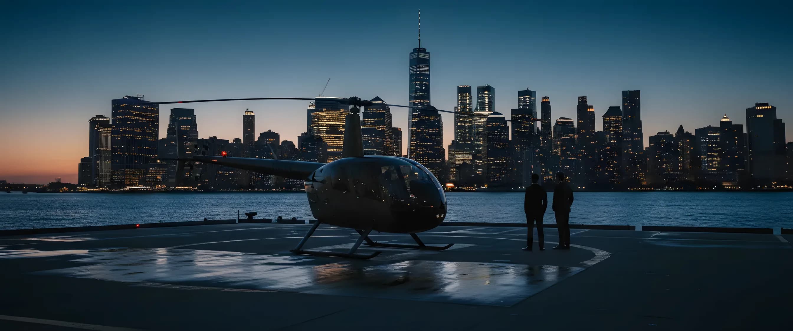 A helicopter on a helipad at dusk with the New York City skyline in the background.